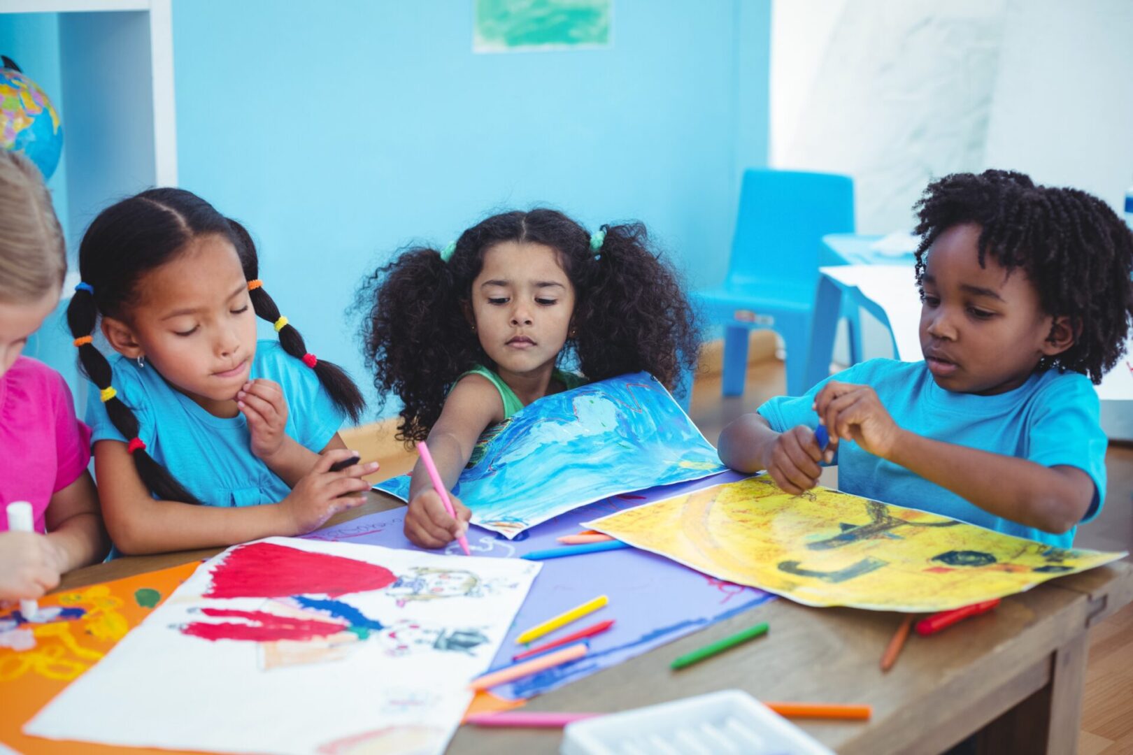 A group of children expertly painting on paper.