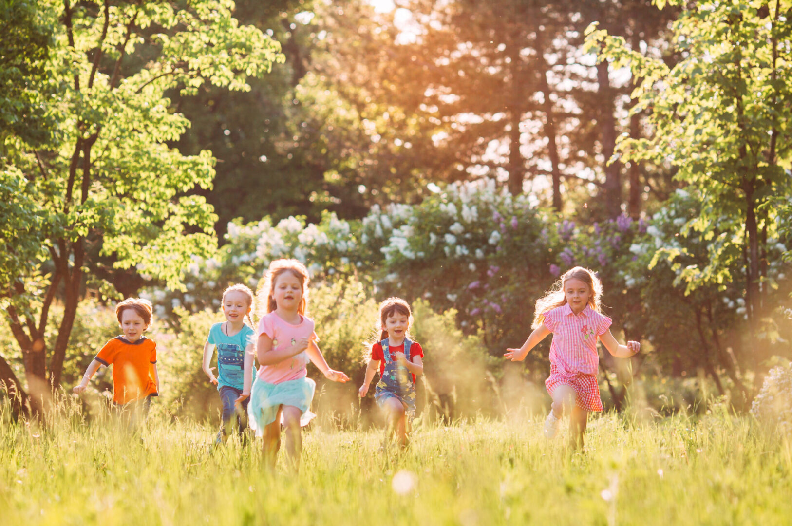 A group of children running in a grassy field, embodying the energetic and playful qualities.