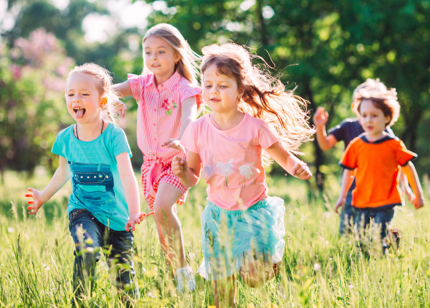 A group of children displaying the qualities of the Pisces sign as they run in a field.